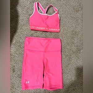 Neon pink Under Armour sports bra and cycling shorts set.